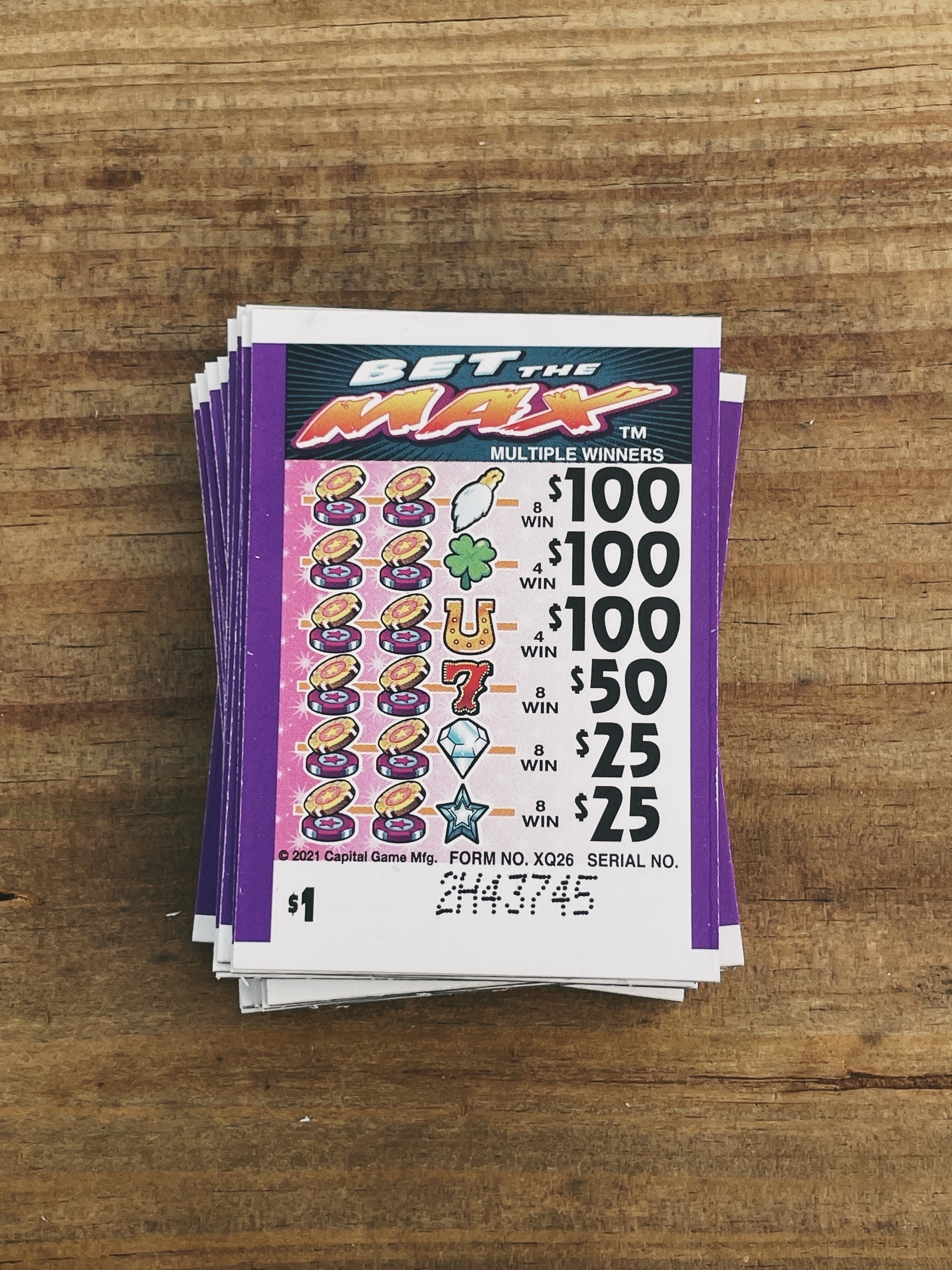 small stack of pull-tabs titled Bet the Max on wood tabletop