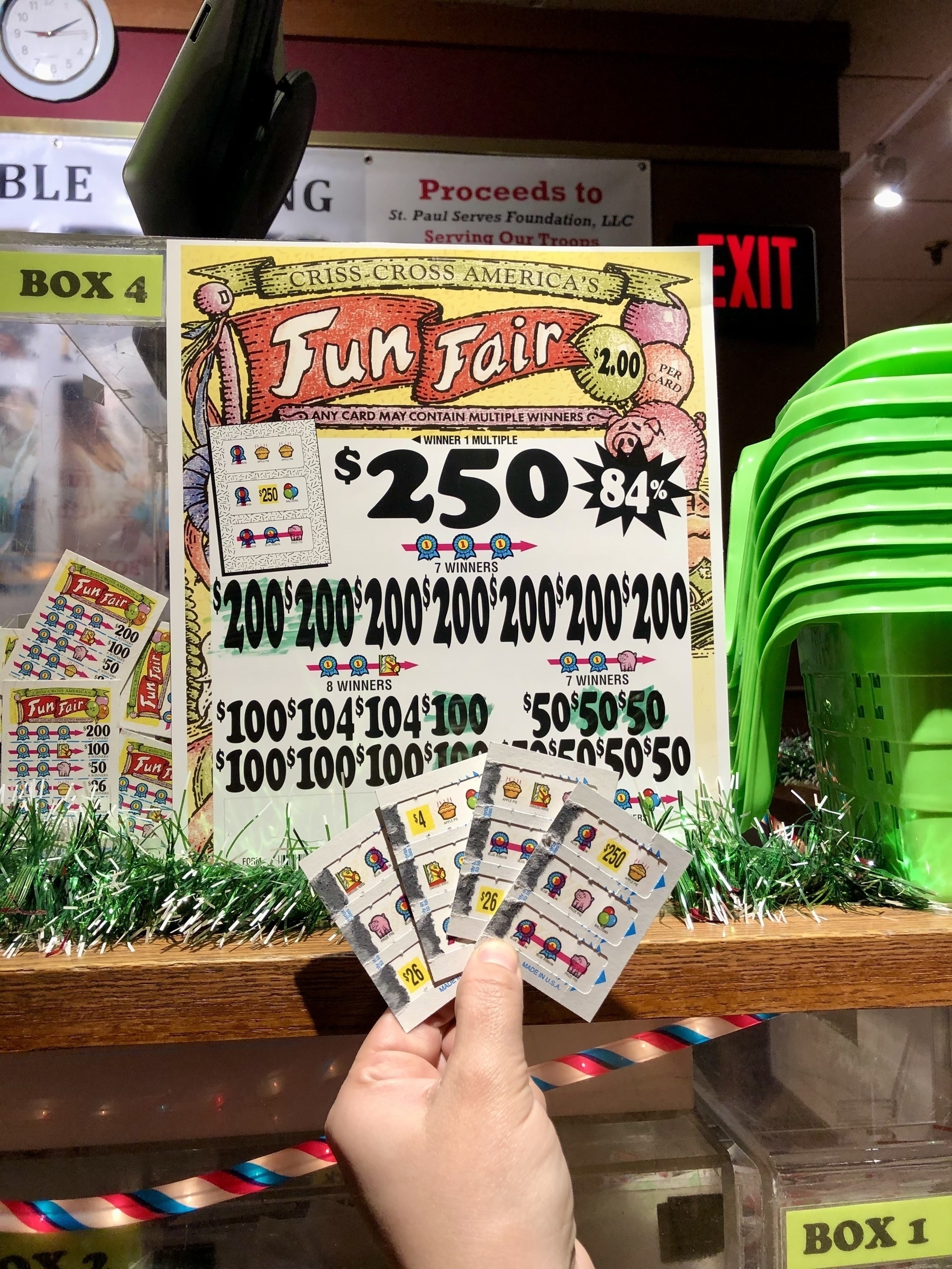 Fun Fair theme of pull-tabs, raised in a hand in front of the pull-tab kiosk