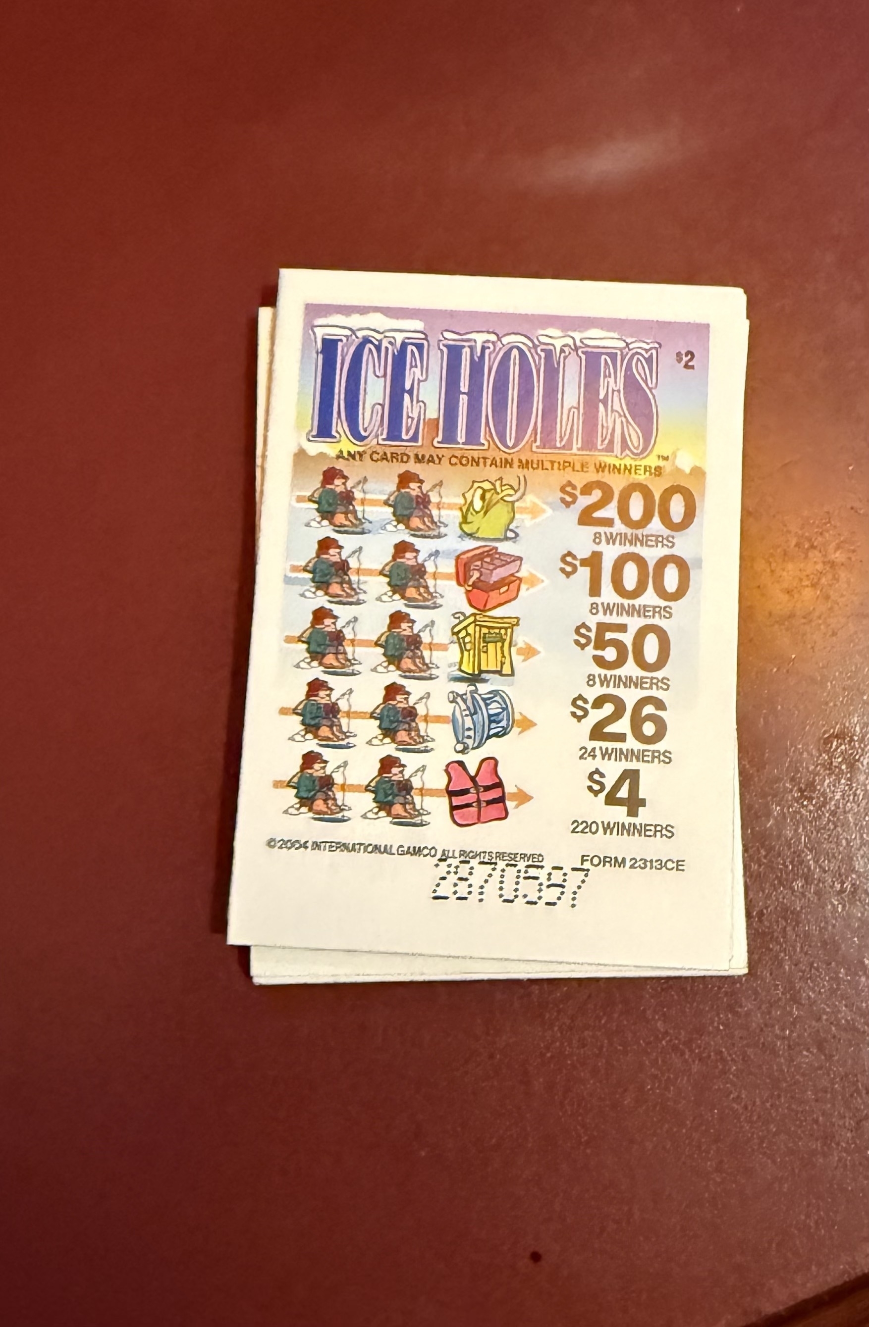 A pull-tab ticket titled Ice Holes features various prize categories and amounts.